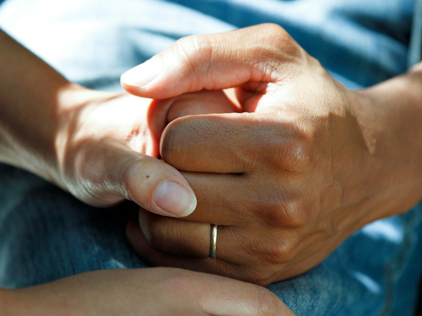 A caregiver gently holding an elderly person's hands